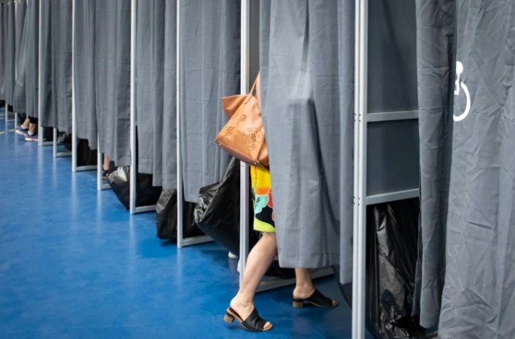 Une électrice entre dans l'isoloir pour voter aux élections européennes à Anse Vata, district de Noumea, en Nouvelle-Calédonie (France), le 9 juin 2024