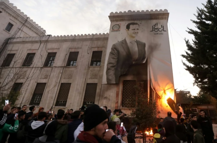 Des résidents mettent le feu à un portrait géant du président syrien à Hama, après la prise de la ville par les rebelles, le 5 décembre 2024