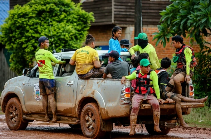 Une jeune fille est évacuée d'une zone inondée par des sauveteurs dans le village laotien de Sanamxai, le 28 juillet 2018.