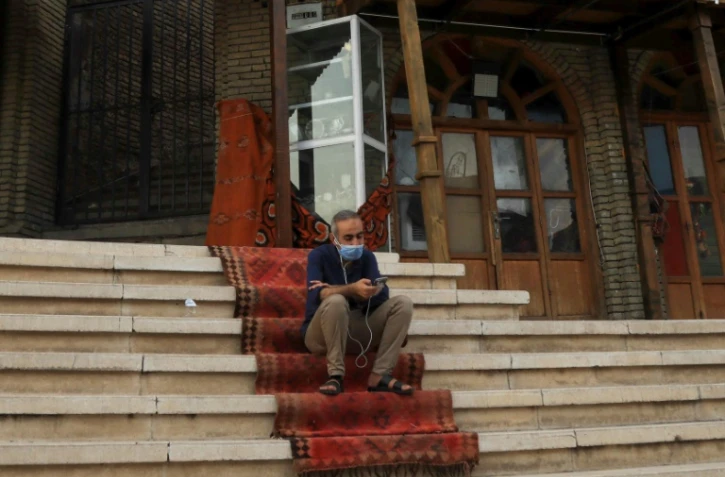 Un homme portant un masque consulte son téléphone à Erbil, au Kurdistan irakien, le 1er juillet 2020 