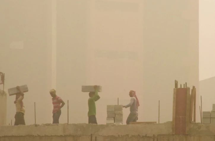 Des ouvriers sur un chantier de construction, un jour de forte pollution à New Delhi, le 7 novembre 2017 en Inde