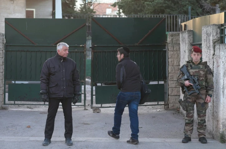 Un soldat français (D) monte la garde devant l'école juive 'La Source' à Marseille, le 12 janvier 2016, au lendemain de l'agression d'un professeur par un adolescent armé d'une machette et d'un couteau.