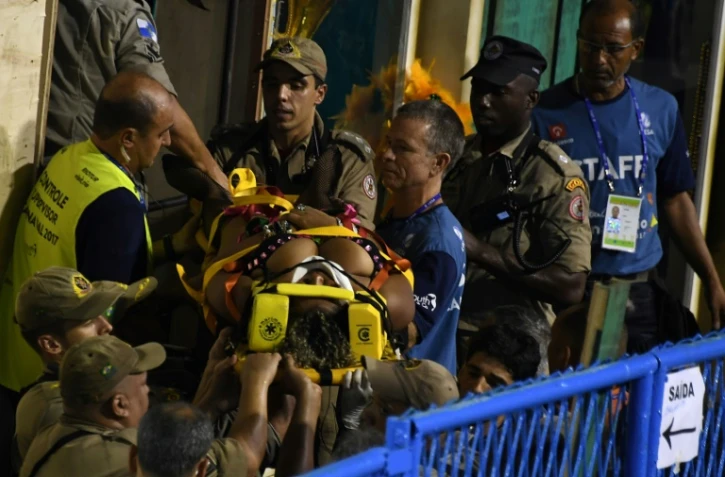 Les pompiers viennent en aide à un membre de l'école de samba des Unidos da Tijuca sur le Sambadrome de Rio de Janeiro, le 28 février 2017