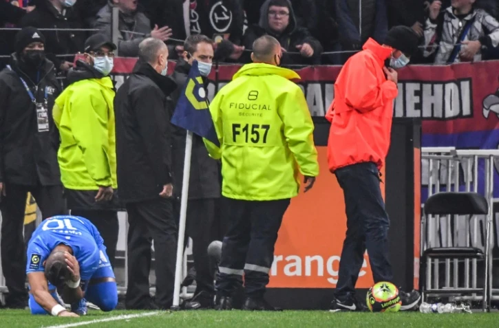 Le meneur de jeu de l'OM Dimitri Payet touché par une bouteille d'eau lancée par un supporter lyonnais depuis le virage nord du Parc OL, le 21 novembre 2021 

