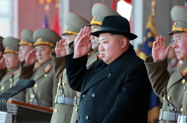 Photo fournie par l'agence nord-coréenne Kcna le 9 février 2018 du leader nord-coréen Kim Jong Un assistant à un défilé militaire, le 8 février 2018 à Pyongyang