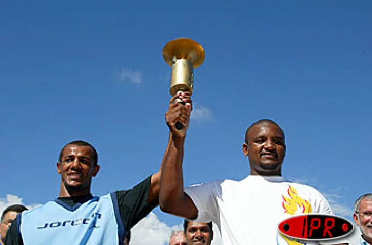 Mardi 19 août 2003-
Le boxeur réunionnais Willy Blain (à gauche) transmet la Flamme des Jeux au judoka mauricien Antonio Félicité