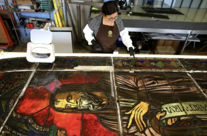 Flavie Vincent-Petit nettoye et restaure des vitraux de la cathédrale Notre-Dame de Paris, dans son atelier à Troyes, dans l'Aubele, le 23 juillet 2022 ( AFP / FRANCOIS NASCIMBENI )