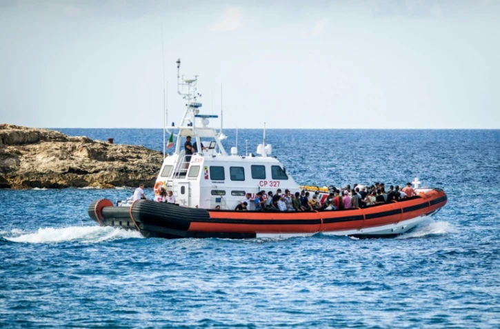 Des migrants embarquent sur un navire militaire italien à Lampedusa