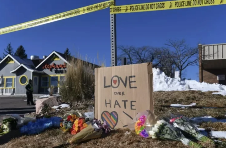 Des bouquets de fleurs et des pancartes forment un mémorial pour les victimes de la fusillade près du Club Q, boîte de nuit LGBT, le 20 novembre 2022 à Colorado Springs ( AFP / Jason Connolly )