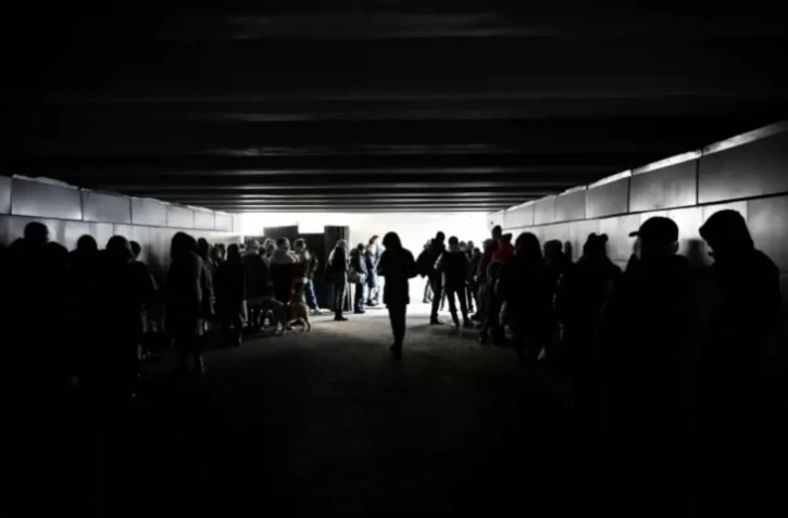 Des passants se mettent à l'abri dans un passage souterrain pendant des frappes de missiles sur Kiev, le 31 décembre 2022 ( AFP / SERGEI CHUZAVKOV )
