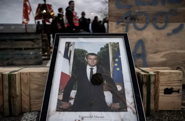 Un portrait d'Emmanuel Macron posé au sol dans une manifestation contre la réforme des retraites, à la centrale nucléaire du Blayais, le 21 mars 2023 à Blaye (Gironde) ( AFP / PHILIPPE LOPEZ )