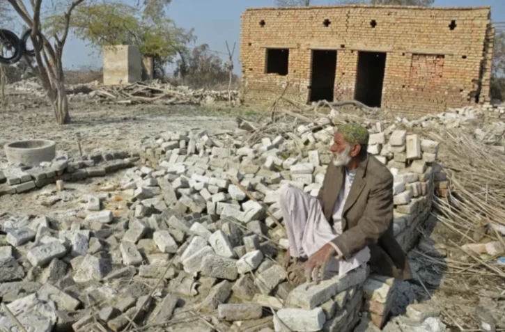 Un homme à proximité de sa maison endommagée par les inondations, à Dera Allah Yar, au Pakistan, le 9 janvier 2023 ( AFP / Fida HUSSAIN )