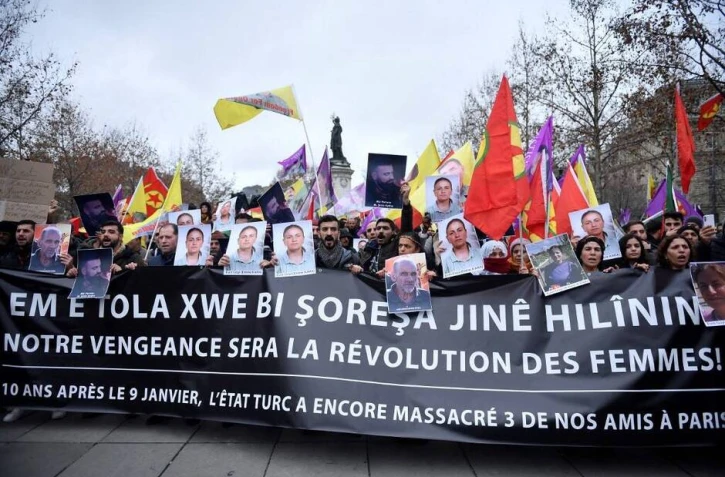 Des manifestants tiennent des portraits de victimes lors d’une manifestation de la communauté kurde, un jour après qu’un homme armé a ouvert le feu sur un centre culturel kurde tuant trois personnes, sur la place de la République à Paris le 24 décembre 2022.