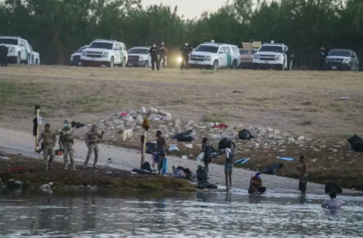 Des migrants haïtiens traversent le Rio Grande vers les Etats-Unis sous la surveillance de la police aux frontières américaine à Ciudad Acuna (Mexique) le 23 septembre 2021 ( AFP / PAUL RATJE )